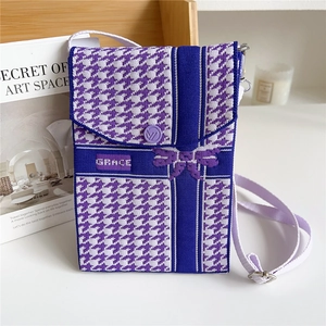 Detail of purple houndstooth knitted phone bag with GRACE logo and fabric strap