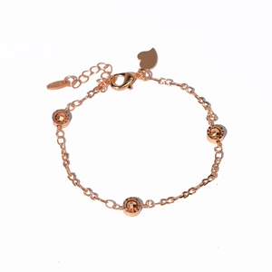Detail shot of 14K rose gold butterfly bracelet featuring faceted beads and heart charm