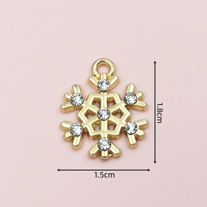 Detailed view of a golden snowflake charm with white rhinestones measuring 1.8cm by 1.5cm