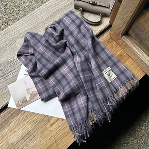 Checkered purple and gray cashmere-like scarf with tassels on vintage wood background