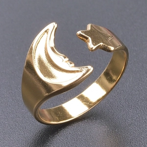 Detail of golden stainless steel open ring featuring crescent moon and star design