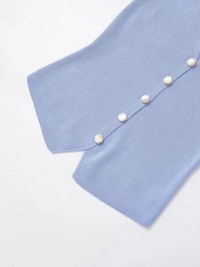 Gros plan sur le gilet en maille bleu clair avec d'élégants boutons dorés ronds