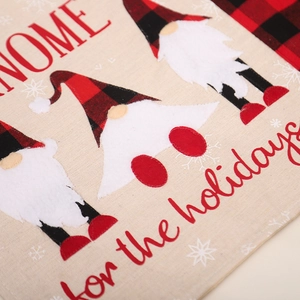 Christmas table mat featuring gnome design and HOME for the holidays text on linen fabric