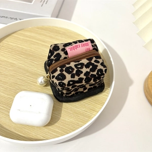 Detail showing leopard print corduroy pouch with pearl pendant zipper for earphone storage