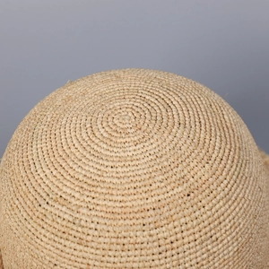 Close-up of the intricate hand-woven raffia texture and natural straw fibers on beach hat