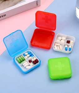 Macro view of portable 4-compartment plastic medicine boxes with cross logo in vibrant colors