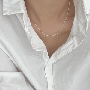 Detailed view of a minimalist 925 sterling silver cube chain necklace on a model
