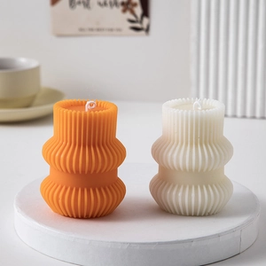 Macro view of geometric pillar candles with vertical stripes in orange and white colors