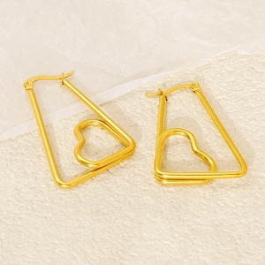 Macro shot of gold geometric heart drop earrings with polished trapezoid frame finish