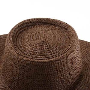 Detailed close-up showing the intricate circular weave of a vintage brown straw hat