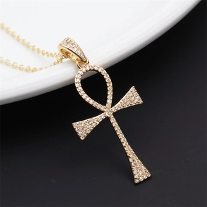 Detailed view of gold plated Ankh cross pendant with pavé set sparkling zircon crystals