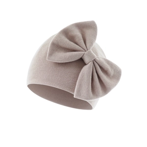 Detailed view of dusty rose ribbed knit texture and large bow on baby beanie