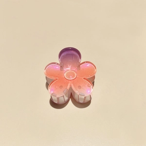 Macro detail of gradient pink flower hair claw clip with subtle glitter finish