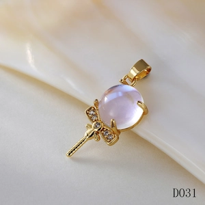 Detailed macro view of a golden magic wand pendant with purple moonstone and bow detail