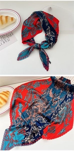 Macro shot of accordion pleated silk scarf with vintage red and blue floral pattern