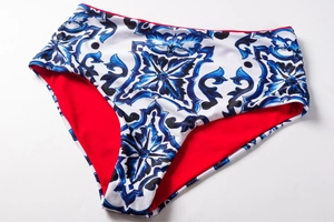 Detail of high-waisted bikini bottom with blue porcelain print and red lining