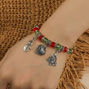 Détail d'un bracelet de Noël avec des perles et breloques bonhomme de neige, cœur et sapin