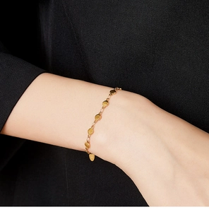 Close-up of 18K gold-plated stainless steel chain bracelet with round discs on wrist