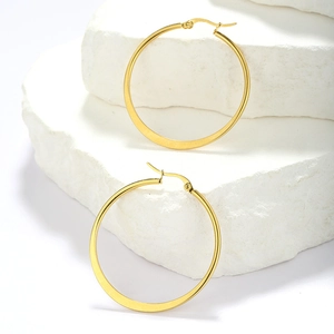 Detail shot of golden round hoop earrings showing polished finish on textured stone base