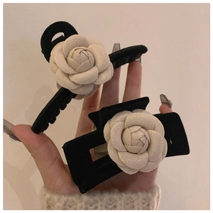 Detail of velvet camellia hair claw and clip showing premium 3D floral craftsmanship