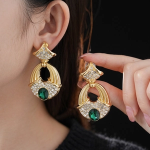 Vintage gold earrings with green gemstones and white rhinestones in a royal court style