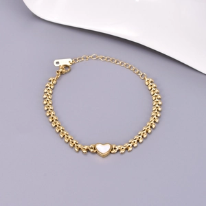 Detail of 18K gold-plated wheat chain with a white heart shell pendant and K18 hallmark