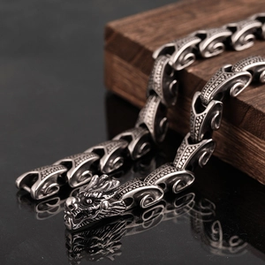Detailed view of the dragon head clasp and fish scale texture on vintage steel necklace