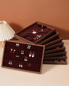Detail of walnut wood jewelry tray with red velvet slots for rings and necklaces