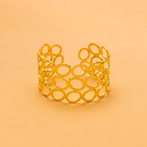 Detail of a gold hollow-out stainless steel bangle featuring interlocking geometric rings