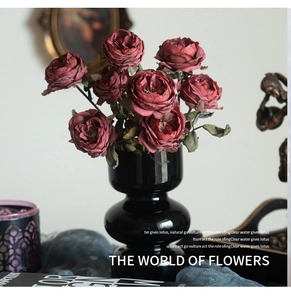 Detail of vintage burnt edge roses in a black ceramic vase for retro home decor