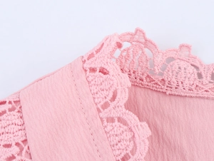 Detailed macro view of the sweet pink dress V-neckline with delicate hollow lace trim work