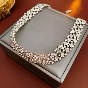 Gros plan du collier ras du cou multicouche en strass sur une boîte à bijoux