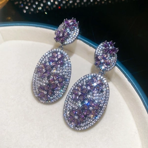 Macro shot of vintage oval floral earrings with purple zircons in a jewelry box