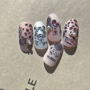 Hand-painted tiger and leopard print nail art stickers with heart and pearl details