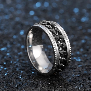 Macro view of rotating spinner ring with black cuban chain inlay and polished steel edges
