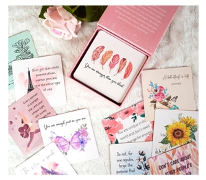 Flat lay of pink affirmation cards with watercolor art and quotes on lace fabric