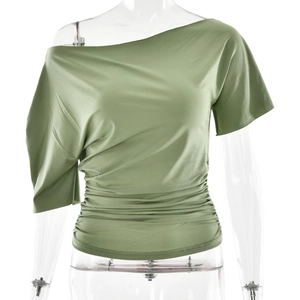 Détail du haut vert asymétrique avec cordon de serrage et plis latéraux sur le côté