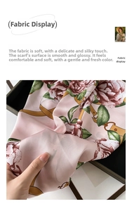 Detail of floral satin scarf showing soft pink fabric with roses and gold buckle pattern