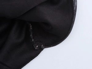Dettaglio della cucitura in rete nera e della trama del tessuto su un abito elegante