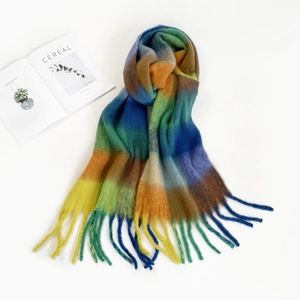 Detail of colorful plaid mohair scarf with tassels on white background with a magazine