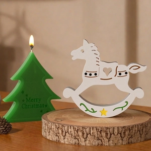 Detailed view of a festive rocking horse ornament on a wood base with holiday decor