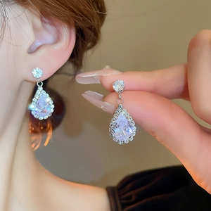 Close-up of elegant silver teardrop earrings with sparkling white zircon stones for women