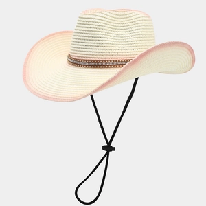 Detail of a woven cowboy hat featuring pink ombre edges and a rhinestone-studded band