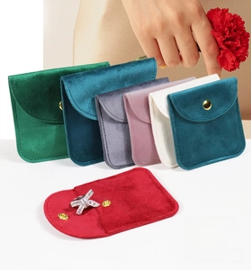 Detail of luxury velvet jewelry pouches with premium gold metal button closures in multiple colors