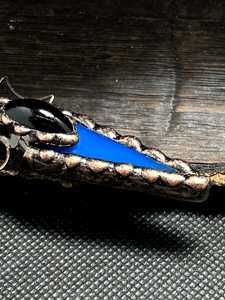 Macro shot of blue agate arrow inlay and amethyst druzy on a bronze-plated pendant
