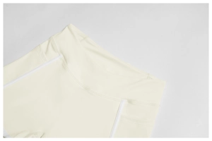 Detail of high-waist cream yoga shorts with white stitching and functional side pocket