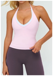 Detail of pink halter yoga vest with deep V-neck and matching dark purple leggings