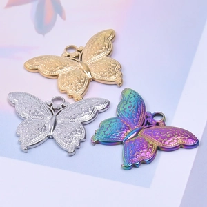 Vue détaillée de trois pendentifs papillon en finition or, argent et acier iridescent poli