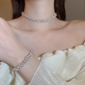 Close-up of pearl and rhinestone woven necklace and bracelet set on a model