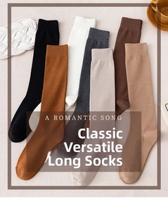 Flat lay of ribbed knit knee high socks in various solid neutral colors with rustic decor